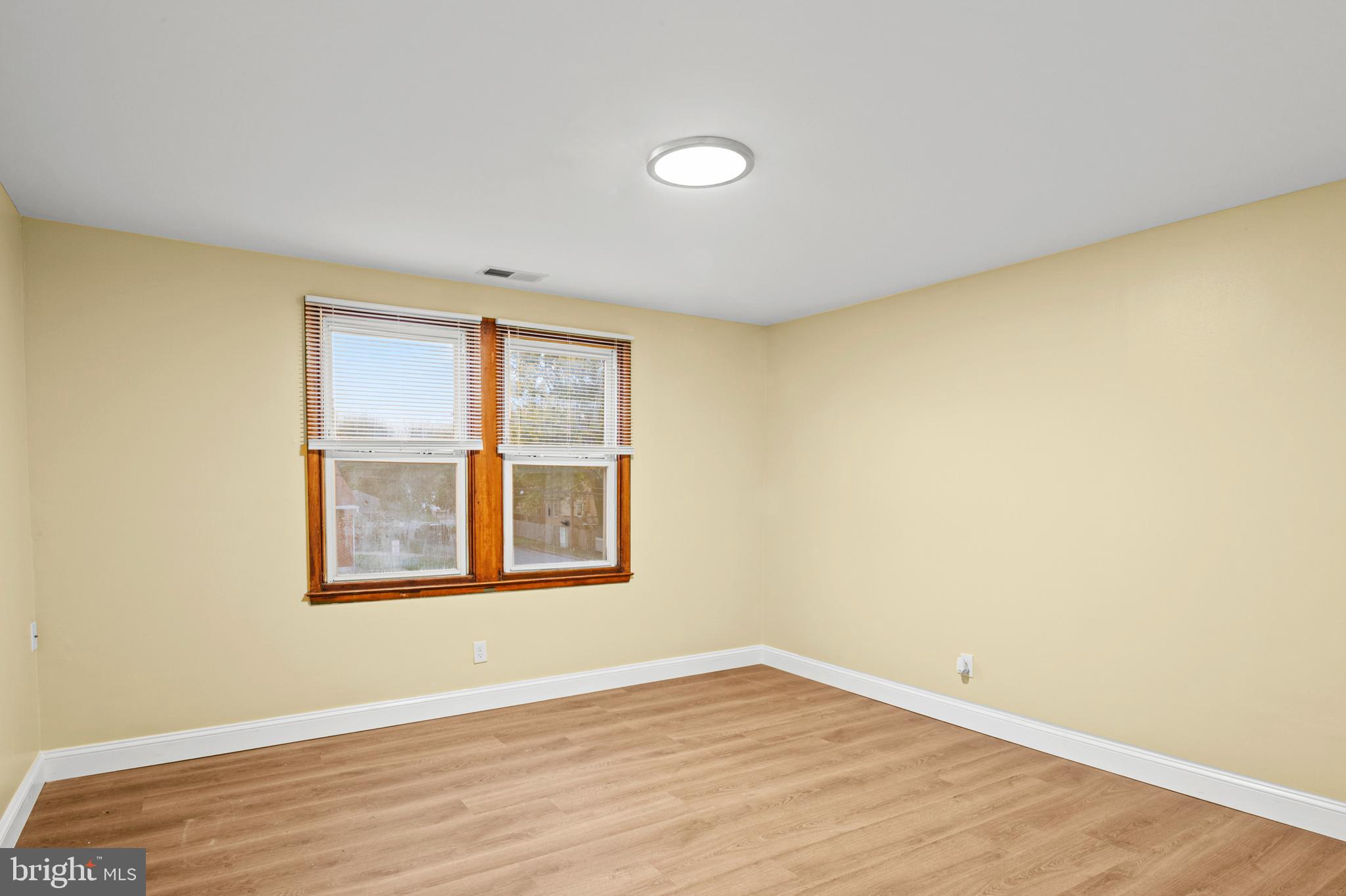 35 3rd Avenue, Unit C Halethorpe, MD 21227 - Photo 12 of 18 a view of an empty room with wooden floor and a window