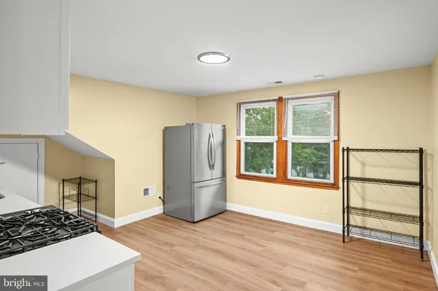 an empty room with wooden floor and a window