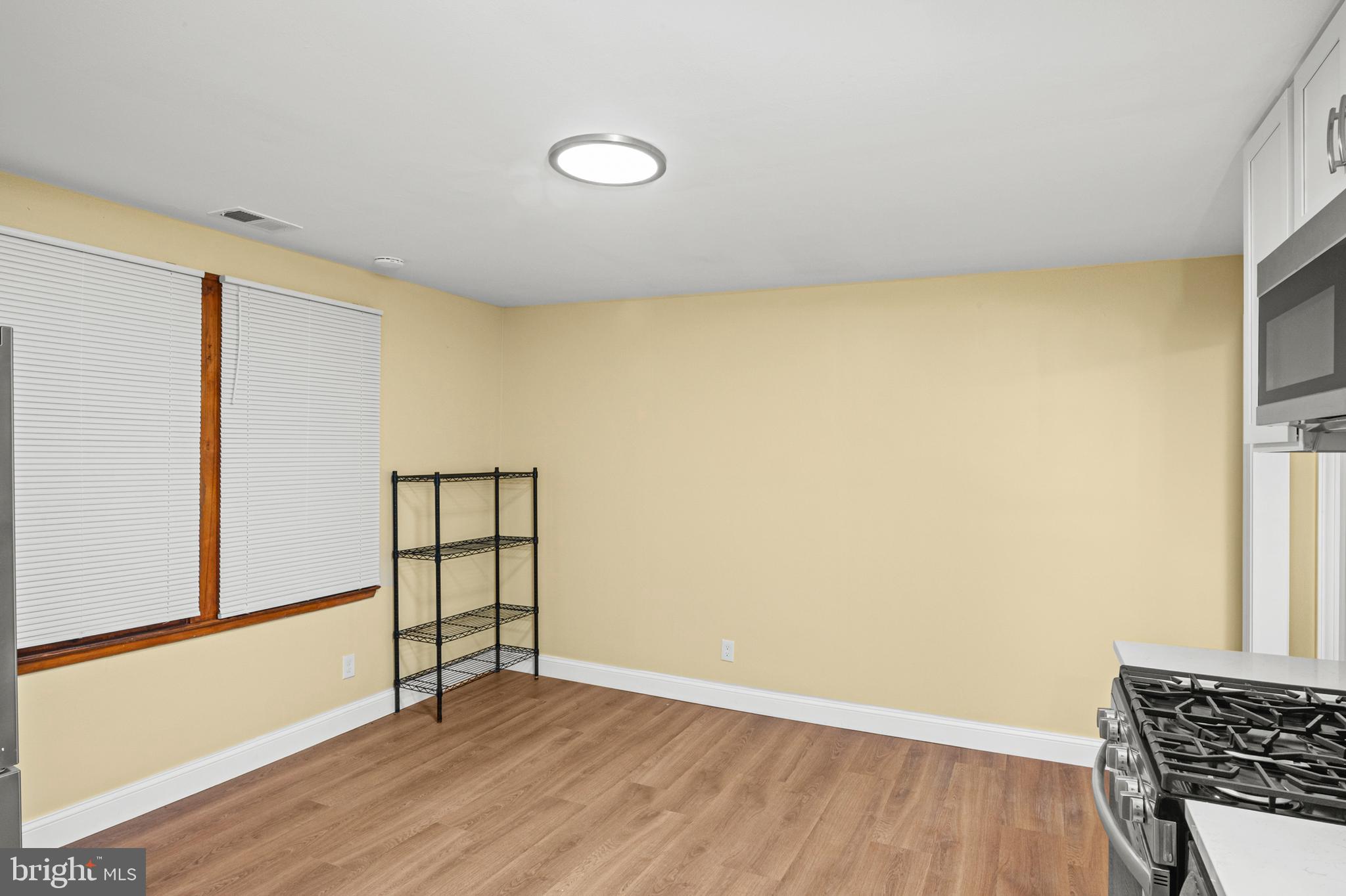 35 3rd Avenue, Unit C Halethorpe, MD 21227 - Photo 6 of 18 a view of an empty room with wooden floor and a window