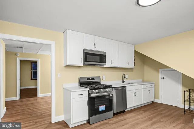 a kitchen with a sink cabinets and wooden floor