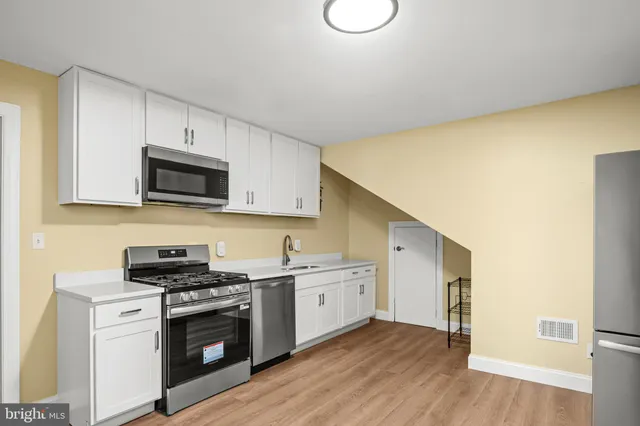 a kitchen with stainless steel appliances a sink a stove a microwave and cabinets