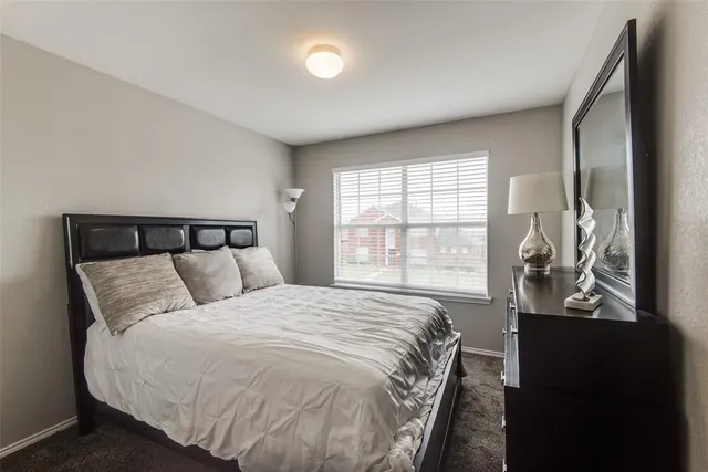 a large bed sitting in a bedroom next to a window