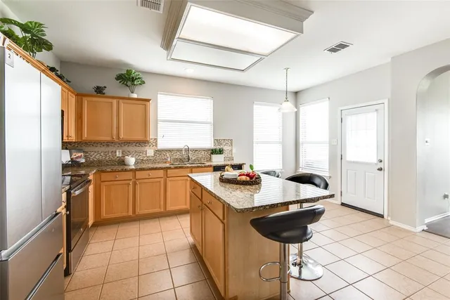 a large kitchen with a stove a sink dishwasher and a refrigerator