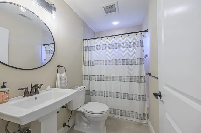 a bathroom with a sink mirror toilet and shower