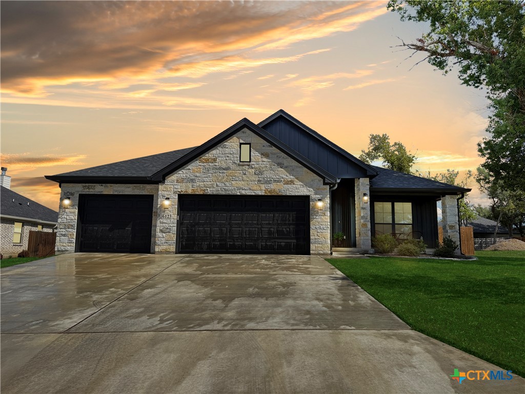 a front view of a house with yard and trees