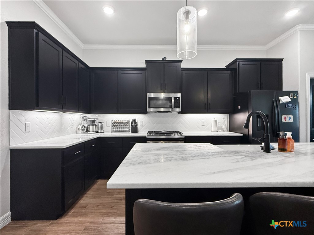 6123 Parma Lane Temple, TX 76502 - Photo 13 of 44 a kitchen with stainless steel appliances kitchen island granite countertop a sink a stove and refrigerator