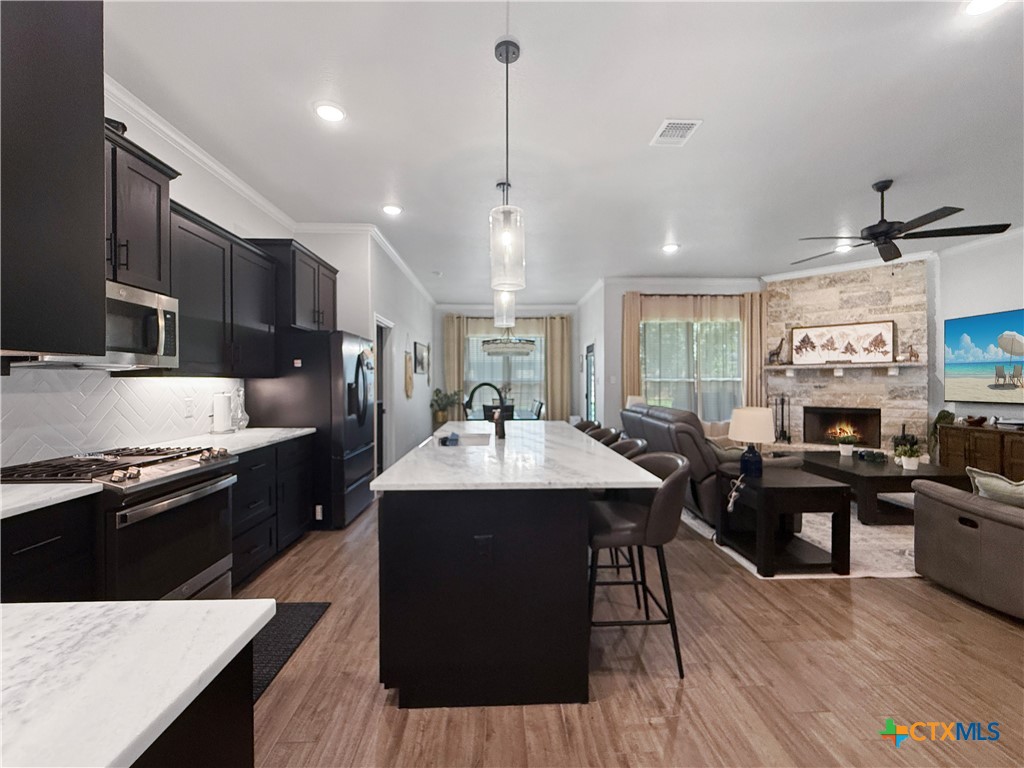 6123 Parma Lane Temple, TX 76502 - Photo 14 of 44 a kitchen with stainless steel appliances granite countertop a sink stove and wooden floor