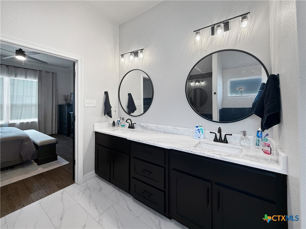 6123 Parma Lane Temple, TX 76502 - Photo 27 of 44 a en suite bathroom with a double vanity sink and a mirror