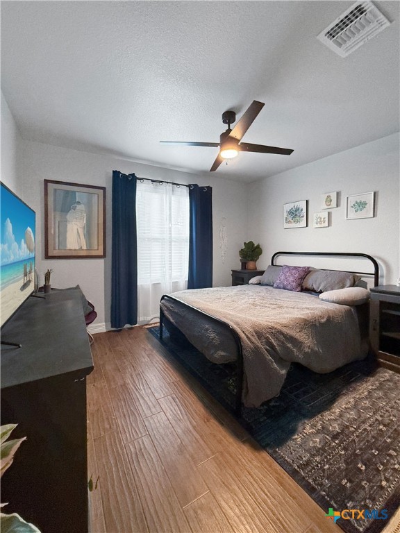 6123 Parma Lane Temple, TX 76502 - Photo 34 of 44 a bedroom with a large bed and a flat tv screen on dresser