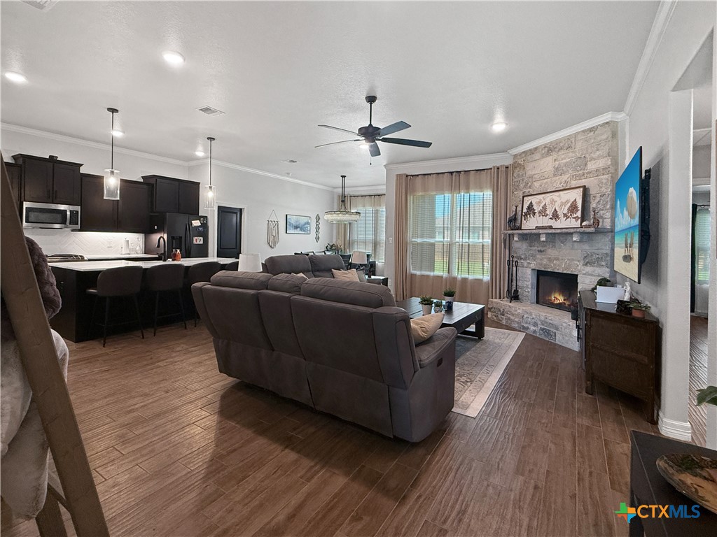 6123 Parma Lane Temple, TX 76502 - Photo 9 of 44 a living room with furniture a fireplace a flat screen tv and kitchen view