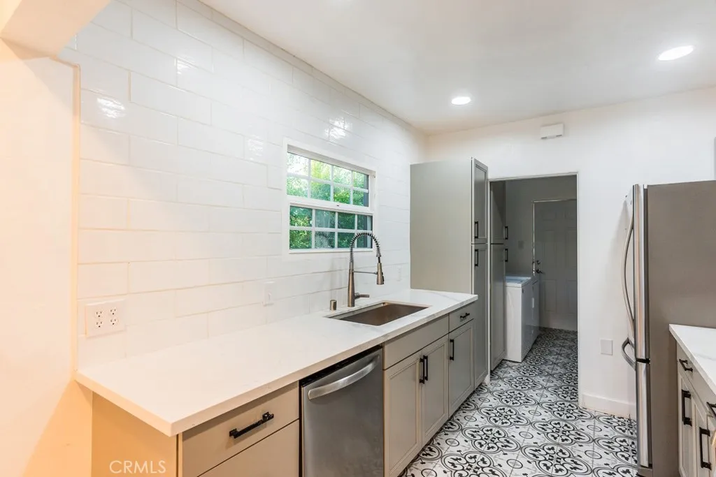 128 South Harper Avenue, Unit 130 Los Angeles, CA 90048 - Photo 15 of 43 a kitchen with stainless steel appliances a sink stove and refrigerator