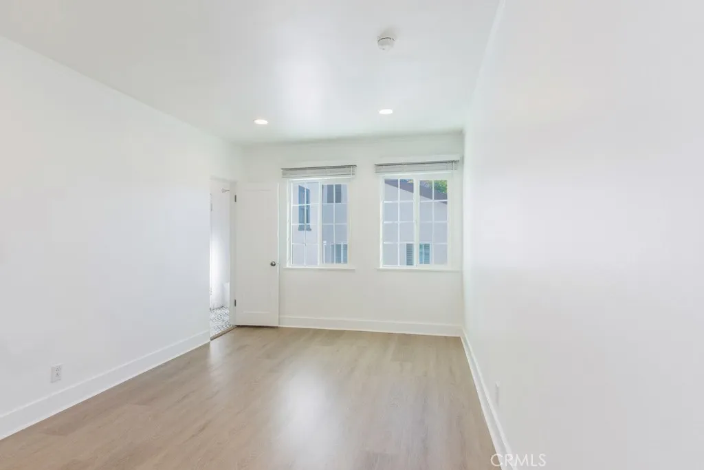 128 South Harper Avenue, Unit 130 Los Angeles, CA 90048 - Photo 22 of 43 an empty room with wooden floor and windows