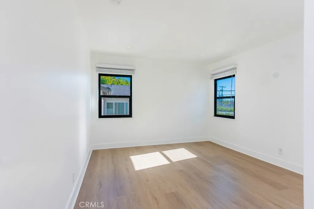 128 South Harper Avenue, Unit 130 Los Angeles, CA 90048 - Photo 23 of 43 an empty room with wooden floor and windows