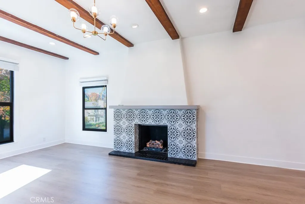128 South Harper Avenue, Unit 130 Los Angeles, CA 90048 - Photo 5 of 43 a view of an empty room with wooden floor fireplace and a window