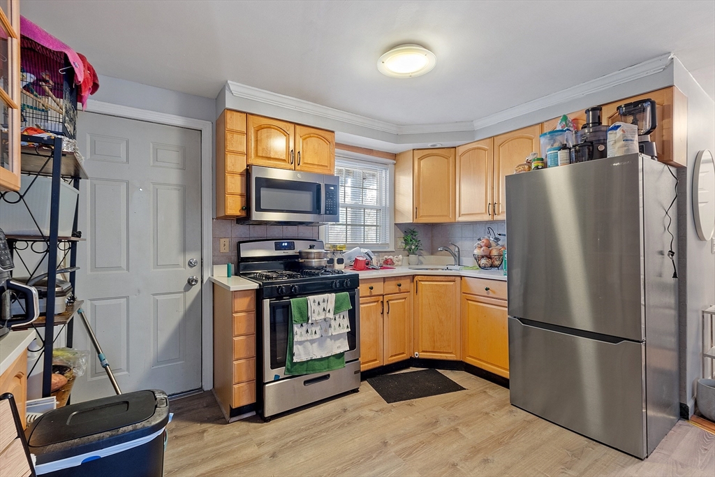 10 Everett Avenue Boston, MA 02125 - Photo 12 of 42 a kitchen with stainless steel appliances a refrigerator sink and white cabinets
