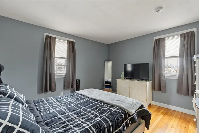 a bedroom with a bed and a flat tv screen on wall