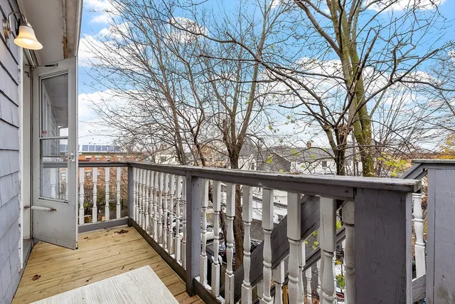 a view of a pathway of a house with wooden fence and floor
