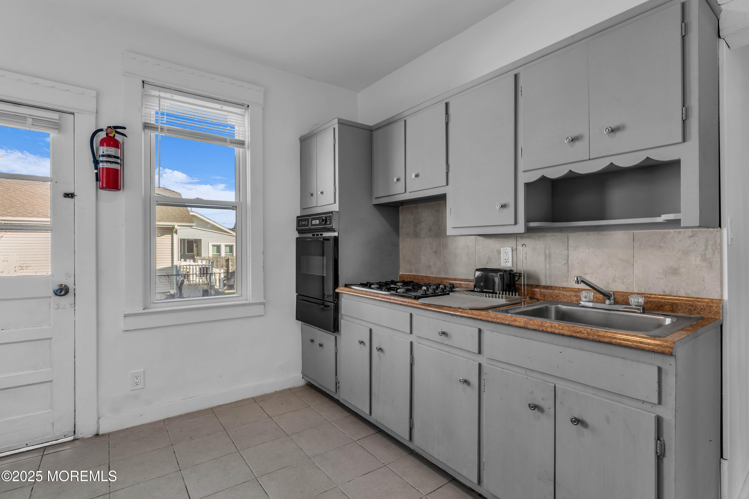 116 15th Avenue Belmar, NJ 07719 - Photo 6 of 21 a kitchen with granite countertop white cabinets and window