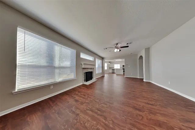 a view of empty room with wooden floor and fireplace