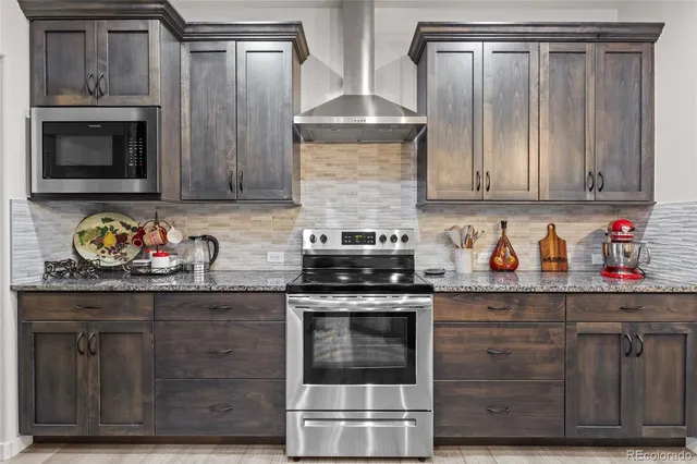 a kitchen with kitchen island granite countertop a sink a counter space appliances and cabinets
