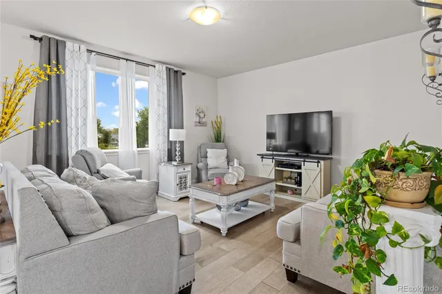 a living room with furniture a rug and kitchen view