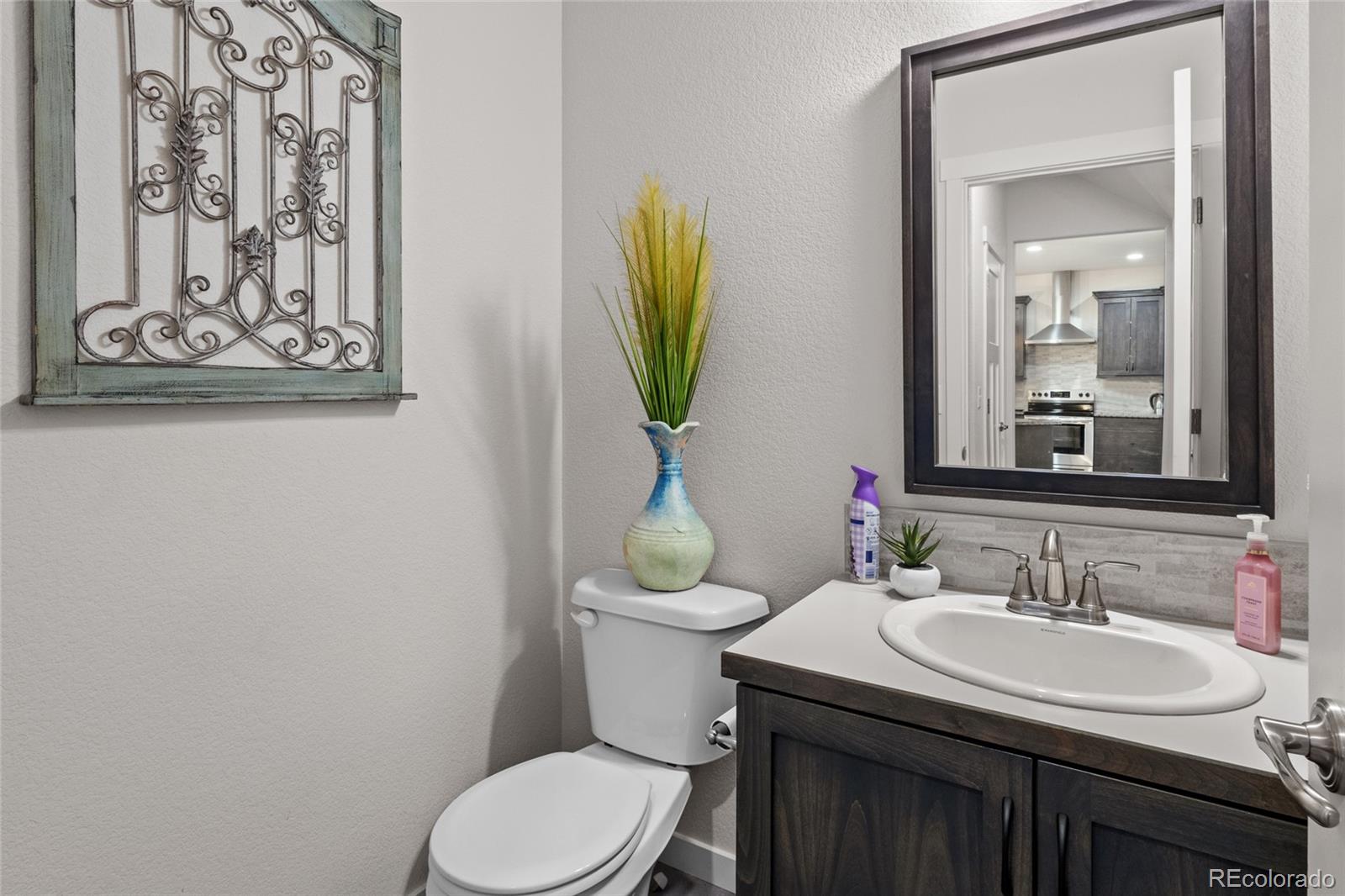 6302 2nd Street Greeley, CO 80634 - Photo 16 of 37 a bathroom with a toilet a sink and mirror