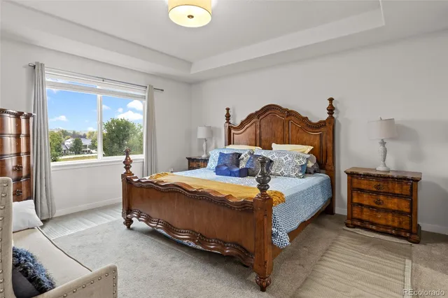 a spacious bedroom with a bed a couch and dresser