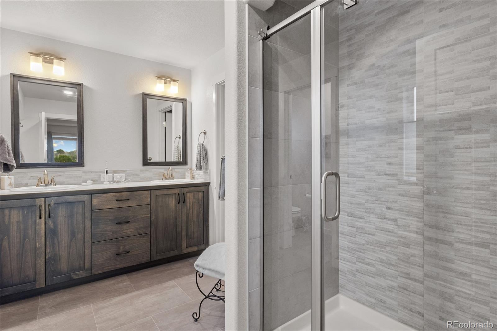 6302 2nd Street Greeley, CO 80634 - Photo 20 of 37 a spacious bathroom with a granite countertop sink mirror and shower