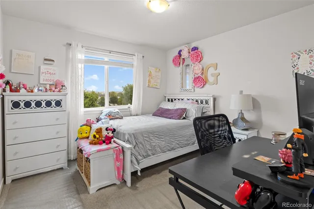 a bedroom with bed and a desk