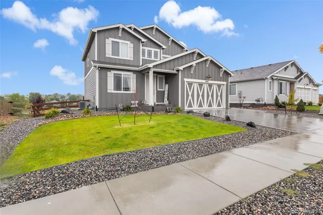 a view of a yard in front of a brick house with a large windows