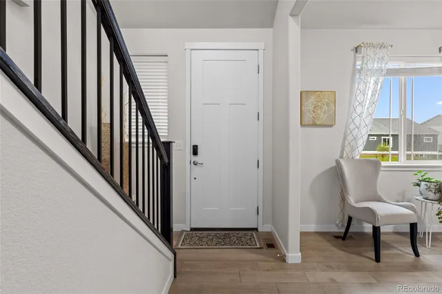a view of a hallway with wooden floor and stairs