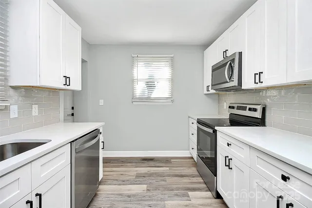 a kitchen with stainless steel appliances white cabinets and a sink