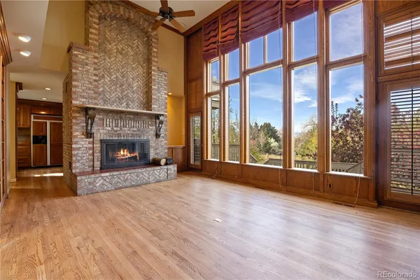 wooden floor fireplace and windows in an empty room