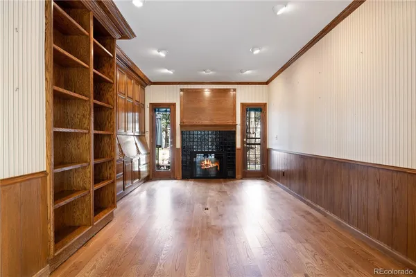 a view of a room with wooden floor fireplace and windows