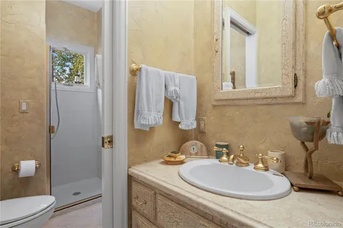 a bathroom with a granite countertop sink toilet and shower