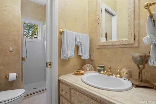a bathroom with a granite countertop sink toilet and shower