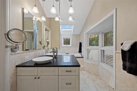 a spacious bathroom with a granite countertop sink a toilet and mirror
