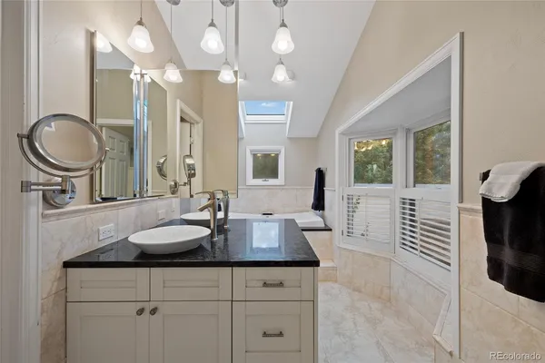 a spacious bathroom with a granite countertop sink a toilet and mirror