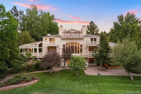 a aerial view of a house with a big yard and potted plants and large trees