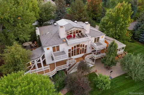 an aerial view of a house with balcony and trees al around