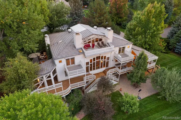 an aerial view of a house with balcony and trees al around