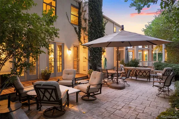a view of a patio with table and chairs under an umbrella