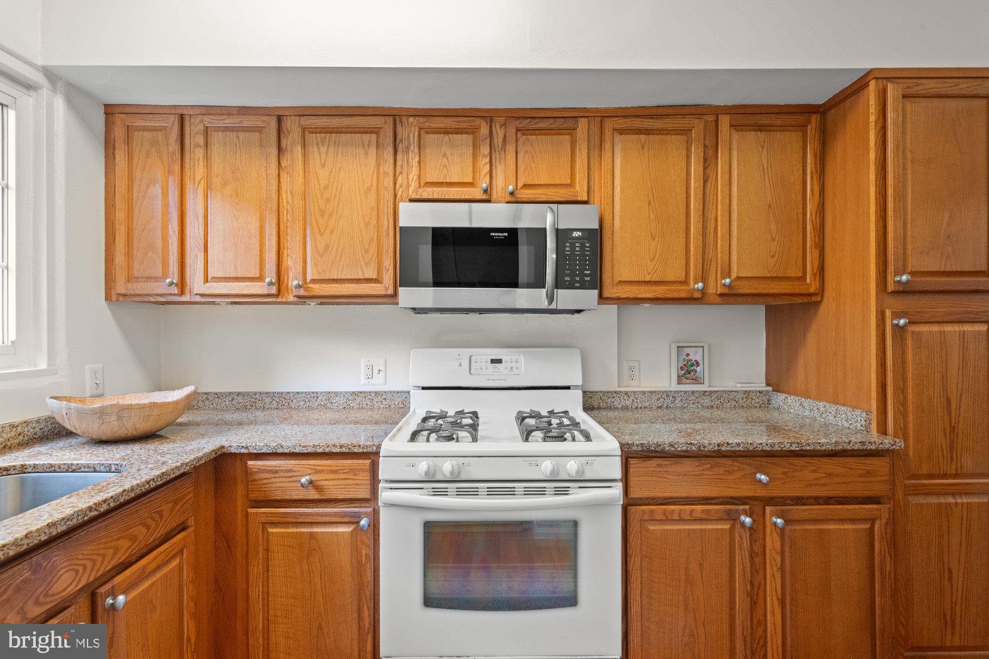 3304 Gunston Road Alexandria, VA 22302 - Photo 11 of 28 a kitchen with granite countertop wood cabinets and a stove top oven