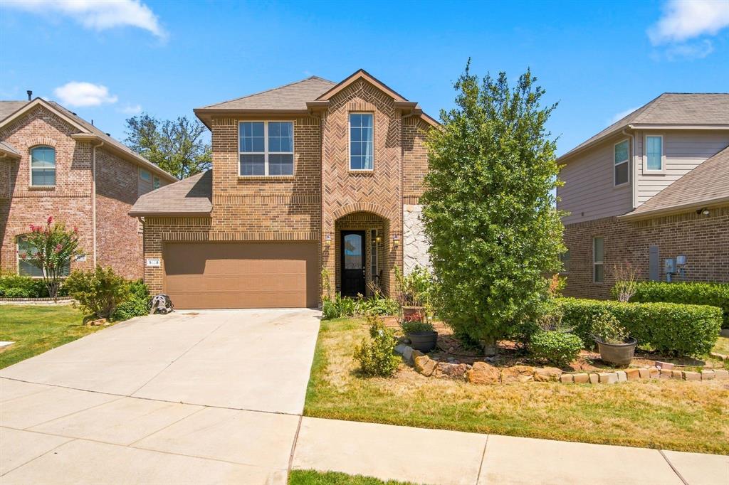 3908 Ranchman Boulevard Denton, TX 76210 - Photo 1 of 29 Brick and stone veneer exterior with a two-car garage, mature landscaping, and a concrete driveway