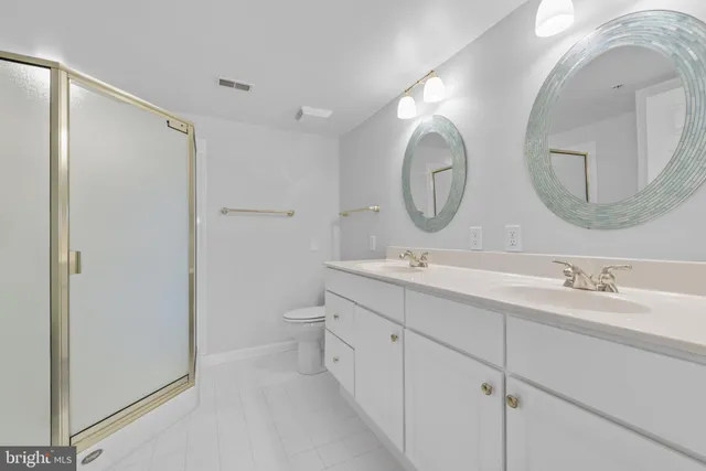 a bathroom with a double vanity sink mirror and a toilet