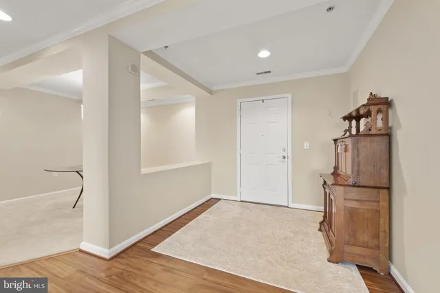 a view of a kitchen with a refrigerator and wooden floor
