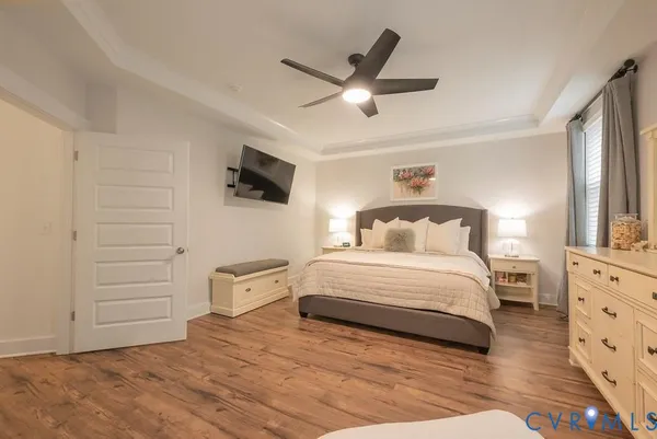 a bedroom with a bed a couch and a flat screen tv