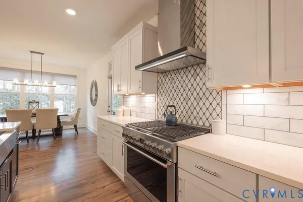 a kitchen that has a stove and a wooden floor