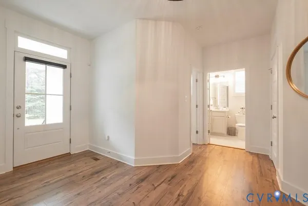an empty room with wooden floor and windows
