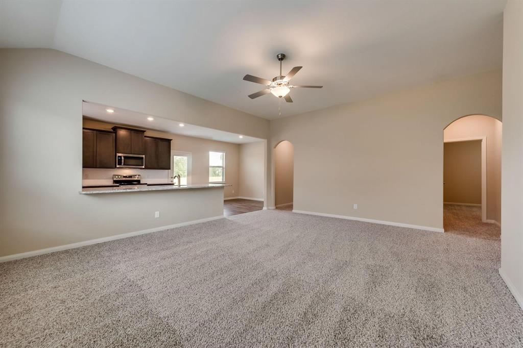 304 Wandering Stream Way Princeton, TX 75407 - Photo 3 of 13 a view of an empty room with a kitchen